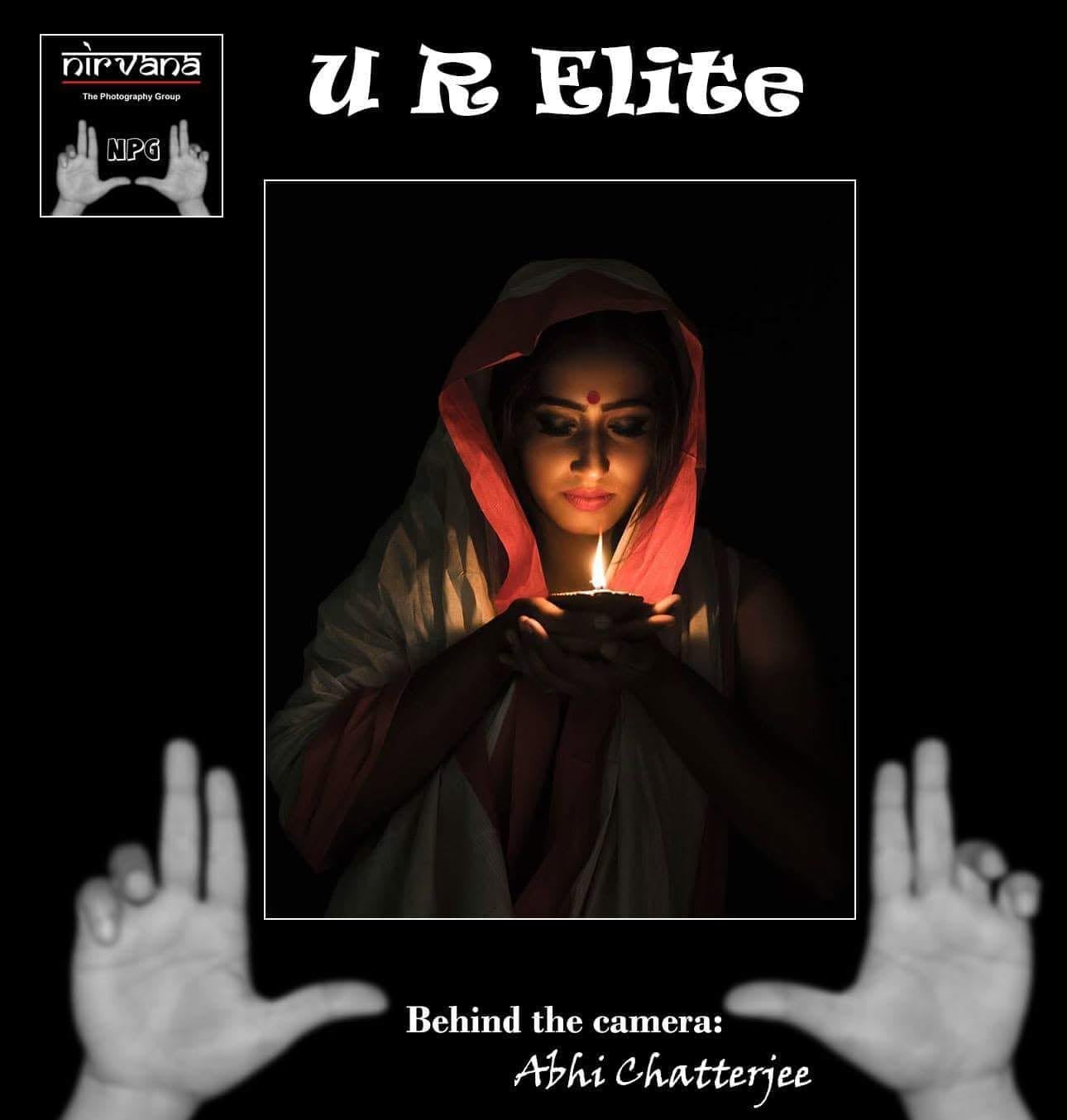 A Nirvana U R Elite feature card showing a woman in a red hood holding a lit diya.