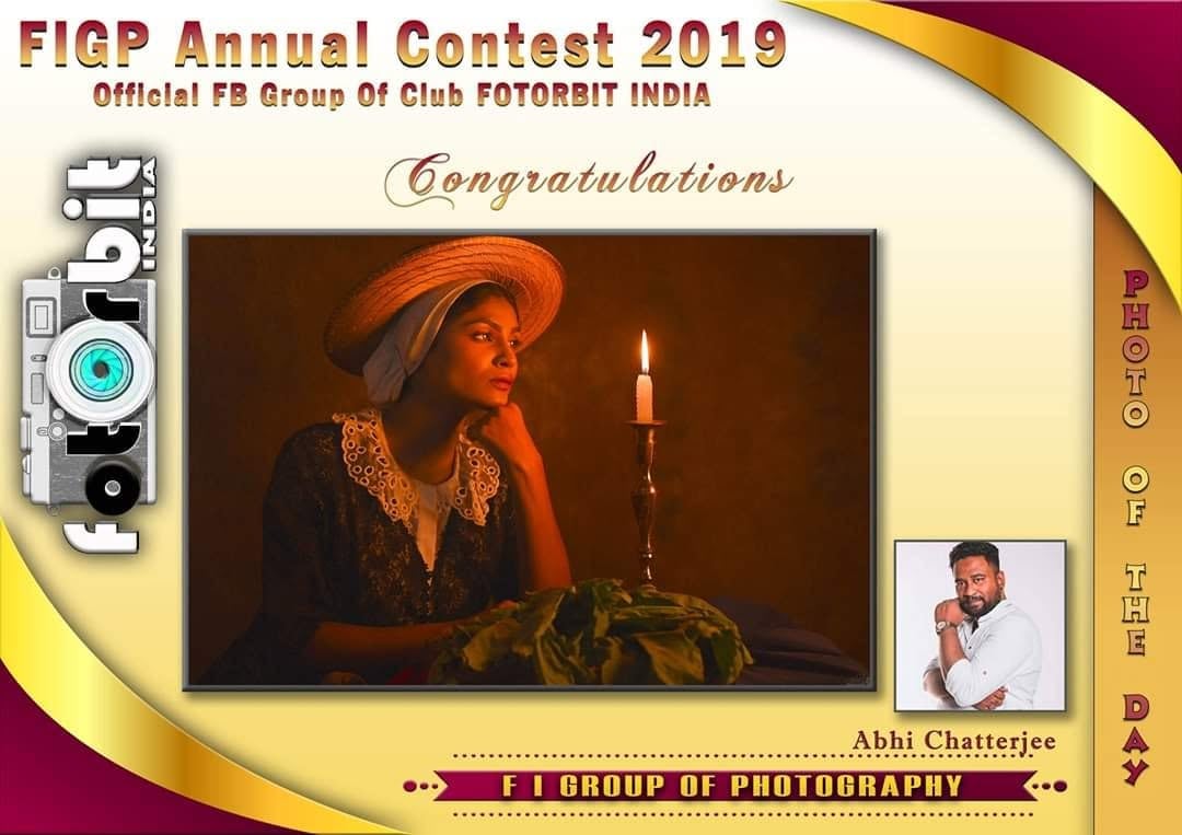A FIGP Annual Contest 2019 card naming a photo of the day, showing a woman in an orange hat by candlelight.